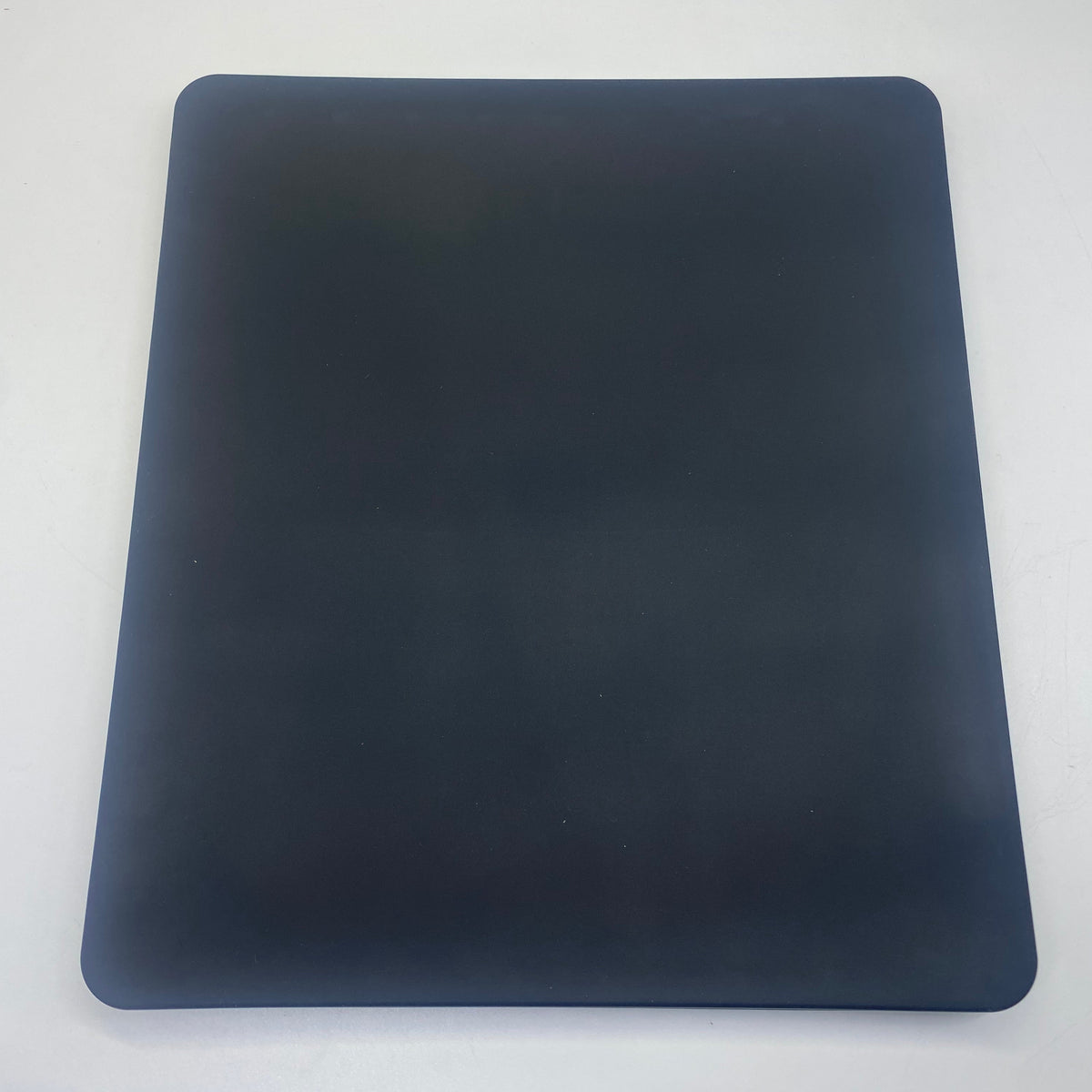 A dark navy blue rectangular mouse pad with rounded corners, photographed flat against a light gray background.